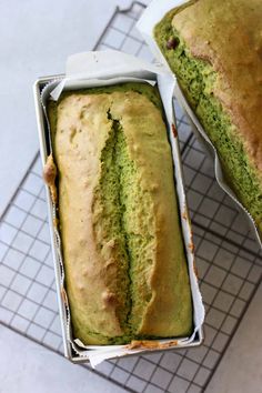 two loafs of green cake sitting on top of a cooling rack next to each other