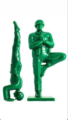 a statue of a man in green sitting on his knees and arms crossed, with one foot up