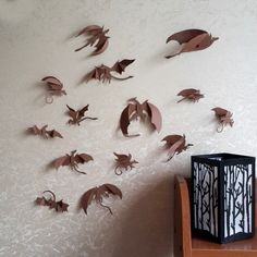 a bunch of bats are hanging on the wall next to a table with a lantern