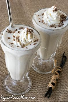 two glasses filled with ice cream and topped with whipped cream