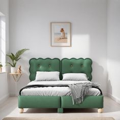 a bed with green headboard and foot board in a white room next to a potted plant