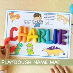 a child's hand is playing with the name charlie on a playdough