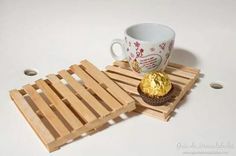 there is a cupcake on a wooden tray next to a coffee mug and coaster