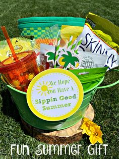 a green bucket filled with candy and snacks on top of a grass covered park area