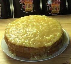 a yellow cake sitting on top of a white plate next to two bags of coffee