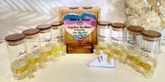 a wooden box with six glass jars and a ribbon tied around the top, sitting on a table