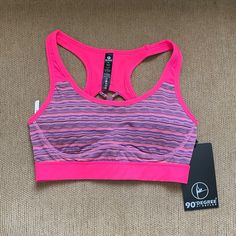 Includes Built In Padding For Support Pink Stretch Sports Bra With Built-in Padding, Pink Snug Fit Activewear For Sports, Pink Sports Bra For Running, Athletic Fit, Pink Athletic Fit Sports Bra For Running, Sporty Pink Sports Bra With Medium Bust Support, Pink Athletic Fit Sports Bra With Go-dry Technology, Sporty Multicolor Racerback Activewear, Pink Activewear With Medium Bust Support, Pink Running Sports Bra With Built-in Padding