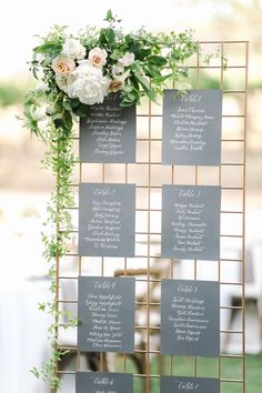 the seating cards were placed on top of each other with greenery and white flowers