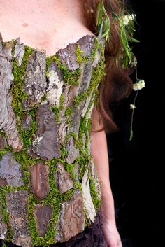 a woman in a corset with moss growing on it