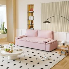 a living room with a pink couch and coffee table on the rug in front of it