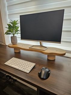 a computer monitor sitting on top of a wooden desk next to a keyboard and mouse