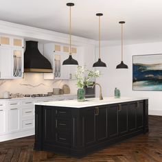 a large kitchen with white cabinets and black island in the center is surrounded by hanging lights