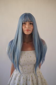 This wig features long, straight hair dyed in a soft pastel blue color, creating a striking yet subtle look. The hair length is approximately 26 inches, allowing it to fall well past the shoulders, almost reaching the waist. The wig has a full fringe (bangs) that frames the face, adding to its stylish and modern appeal. The hair is smooth and sleek, with a natural-looking texture, making it an ideal choice for a unique and eye-catching appearance. Blue Wig Epic Cosplay Wigs, Full Fringe Bangs, Light Blue Wig, Long Blue Hair, Sky Blue Hair, Pastel Wig, Full Fringe, Pastel Blue Color, Wig Straight