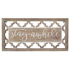 a wooden sign that says stay awhile on the side of a white and brown wall