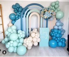 balloons and streamers are arranged on the floor in front of a wall with an arch