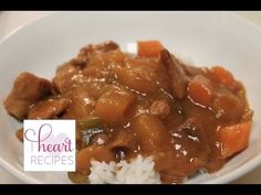 a white bowl filled with rice and meat covered in gravy on top of a table