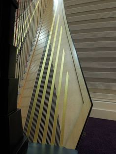 an abstractly designed wall in a building with purple carpeting and vertical blinds on the walls