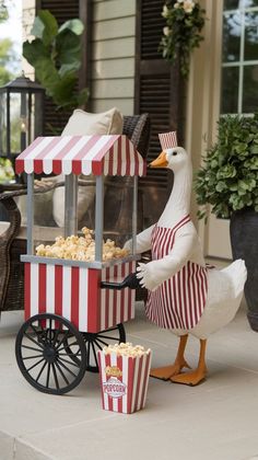 a duck that is standing next to a popcorn cart