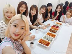 a group of young women sitting at a table with food