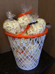 popcorn balls in a plastic basket with orange handles