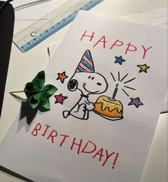 a happy birthday card with a cartoon character holding a cake and a green shamrock next to it