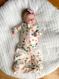 a baby laying on top of a white blanket