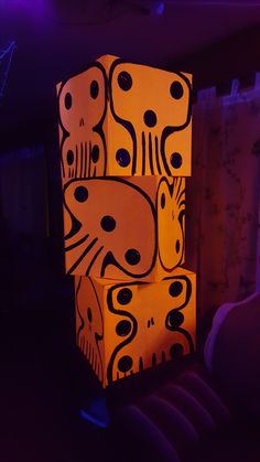 a lit up box sitting on top of a chair in a room with purple lighting