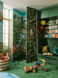 a child's room decorated in green and blue with toys on the floor, bookshelves and wallpaper