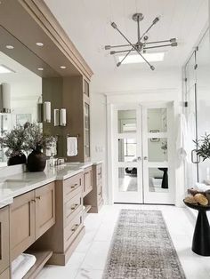 a large bathroom with two sinks and mirrors on the wall, along with a rug