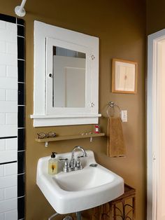 a white sink sitting under a bathroom mirror