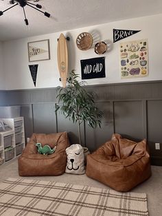 two bean bags sitting on the floor in front of a wall with surfboards and other items