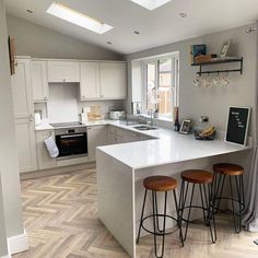 a kitchen with two stools next to an island