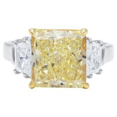 a yellow and white diamond ring with three diamonds on the sides, set in two tone gold