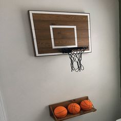 basketballs are sitting on a shelf in the corner of a room next to a bed