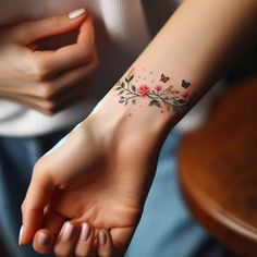 a woman's wrist tattoo with flowers and butterflies on the left side of her arm