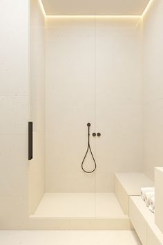 a white bathroom with a shower head and lights on the ceiling, along with benches