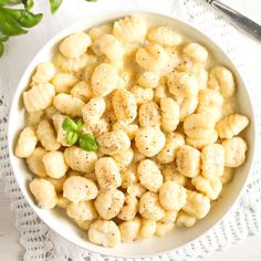 a bowl filled with macaroni and cheese on top of a white doily