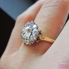 a close up of a person's hand with a diamond ring on their finger