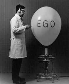 a man standing in front of an egg balloon with the word ego written on it