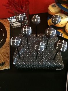 a table topped with cupcakes covered in black frosting and decorated with crosses