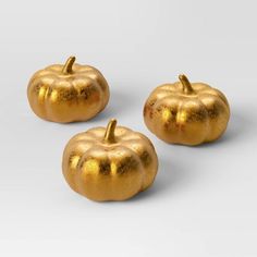 three golden pumpkins sitting next to each other