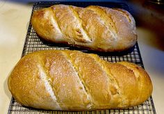 two loaves of bread sitting on top of a cooling rack