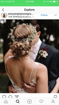 a man and woman standing next to each other in front of trees with flowers on their head