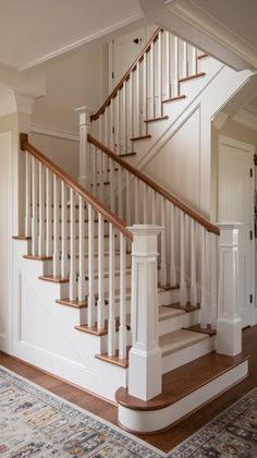 a white staircase with wooden handrails and carpet