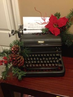 an old fashioned typewriter sitting on top of a table next to a christmas decoration