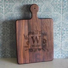 a wooden cutting board sitting on top of a counter next to a wallpapered wall