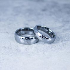 two wedding rings sitting on top of each other