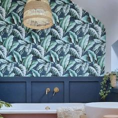 a bath room with a tub and a plant on the wall