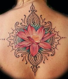 the back of a woman's neck with a lotus tattoo on it