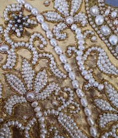 an embroidered fabric with pearls and beads on it